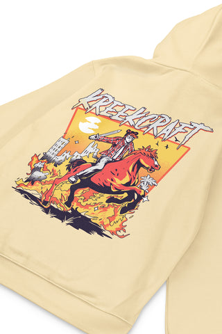 KreekCraft pale yellow hoodie with KreekCraft riding a horse in a burning city artwork on the entire back, in close-up.